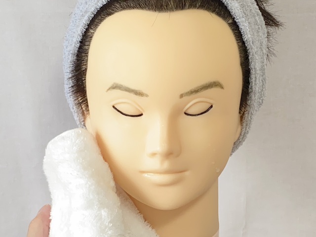 洗顔後にタオルで顔を拭く男性