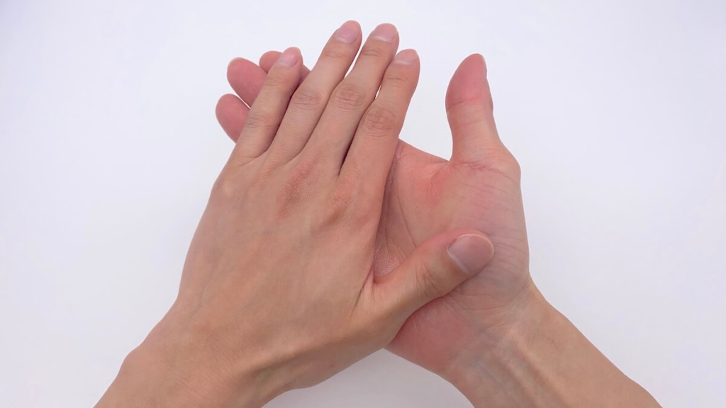 両手で化粧水を伸ばす男性