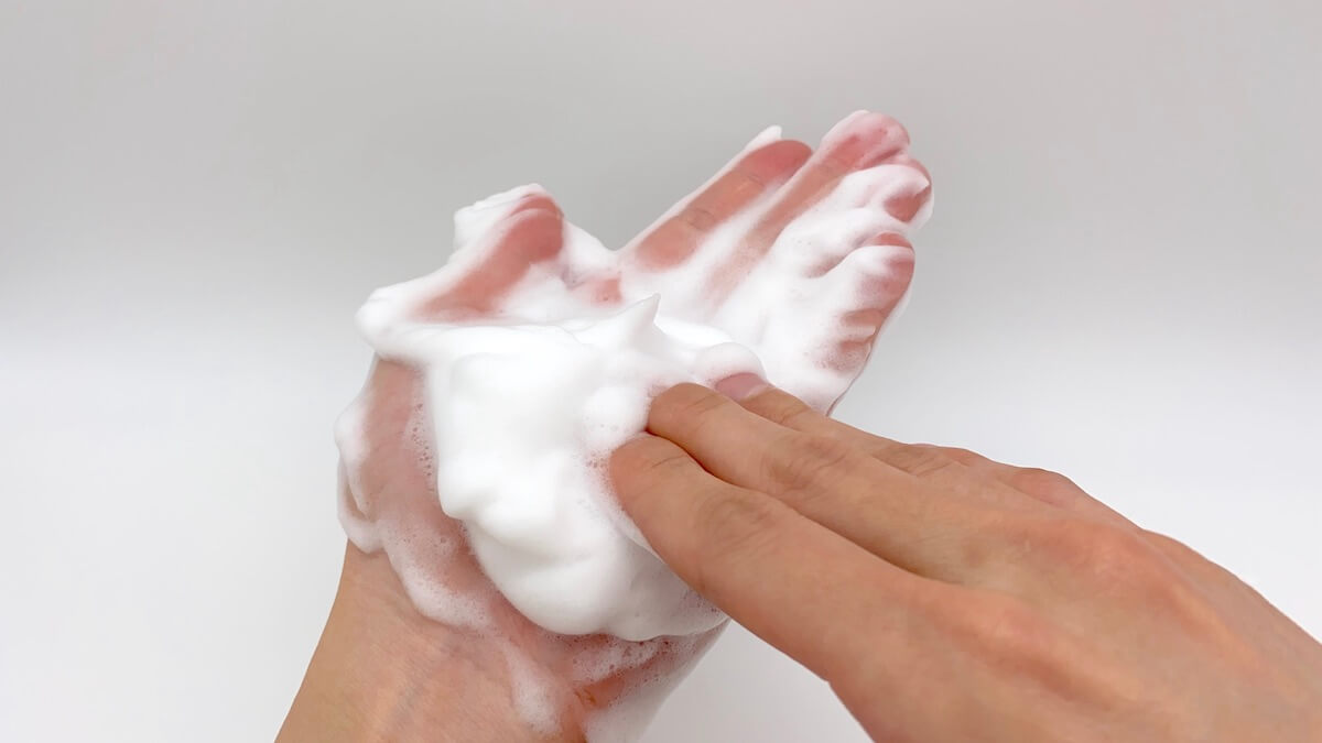 洗顔料を泡立てる男性の手