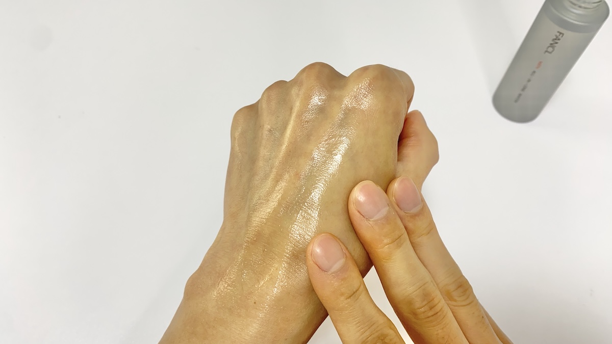 ファンケルメンのオールインワン化粧水を手の甲に塗り広げる