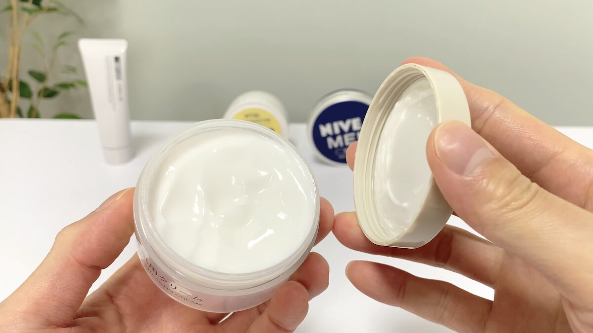 フェイスクリームの蓋を開けて使う男性